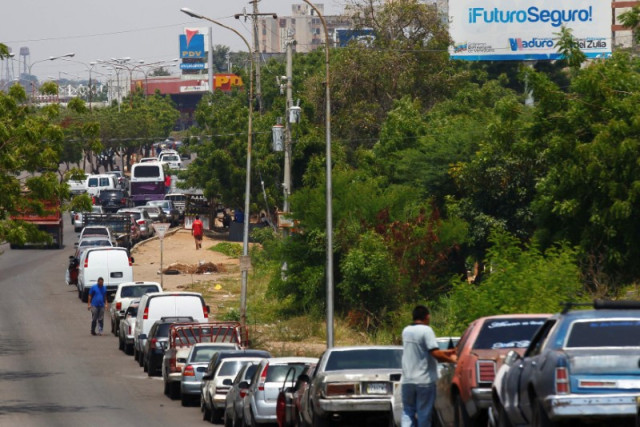 FOTO DE ARCHIVO-Personas y sus vehículos esperan en una fila para repostar combustible en una gasolinera de la petrolera estatal PDVSA en Maracaibo.